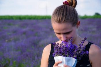 richard-ecsedi-Wv9Bn8te3as-unsplash woman smelling a bouquet of lavender
