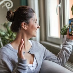 Young Adult Woman with Hearing Aid having video conference.