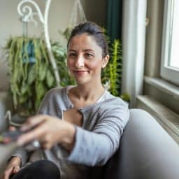Young Adult Woman with Hearing Aid watching television