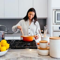 Smiling woman cooking at home.