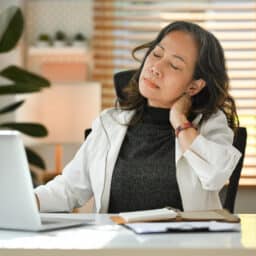 Woman with fibromyalgia rubbing her sore neck