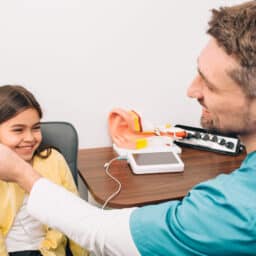 Happy young girl taking a hearing test