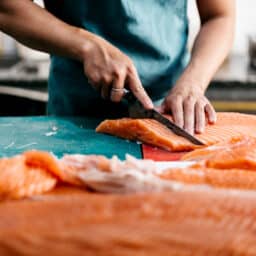 Cook preparing salmon for dinner