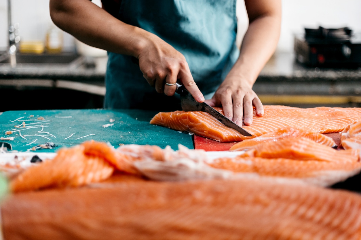 Cook preparing salmon for dinner.