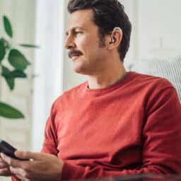 Man wears hearing aids at home