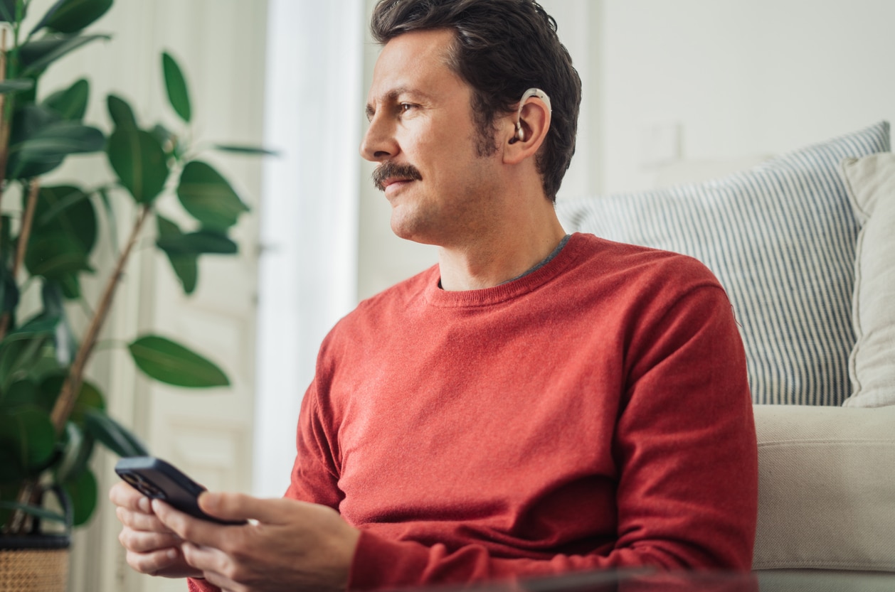 Man wears hearing aids at home