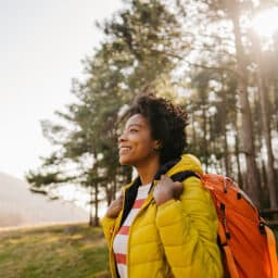 Happy woman hiking and backpacking in a forest in Alabama in the spring.