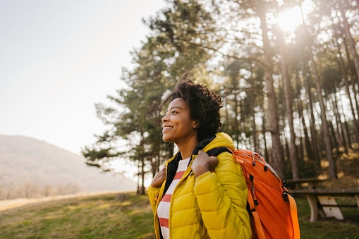 Happy woman hiking and backpacking in a forest in Alabama in the spring.