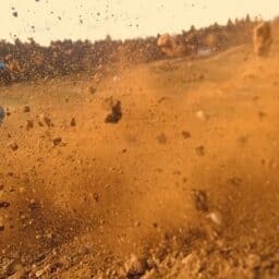 Dirt flies as a motocross rider races over the track.