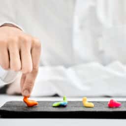 Doctor audiologist demonstrates different types of individual colorful earplugs that are presented on hearing clinic table for patient to choose from.