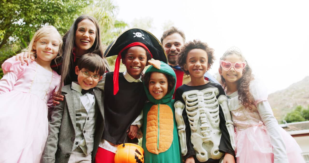 Group of kids smiling in their Halloween costumes.